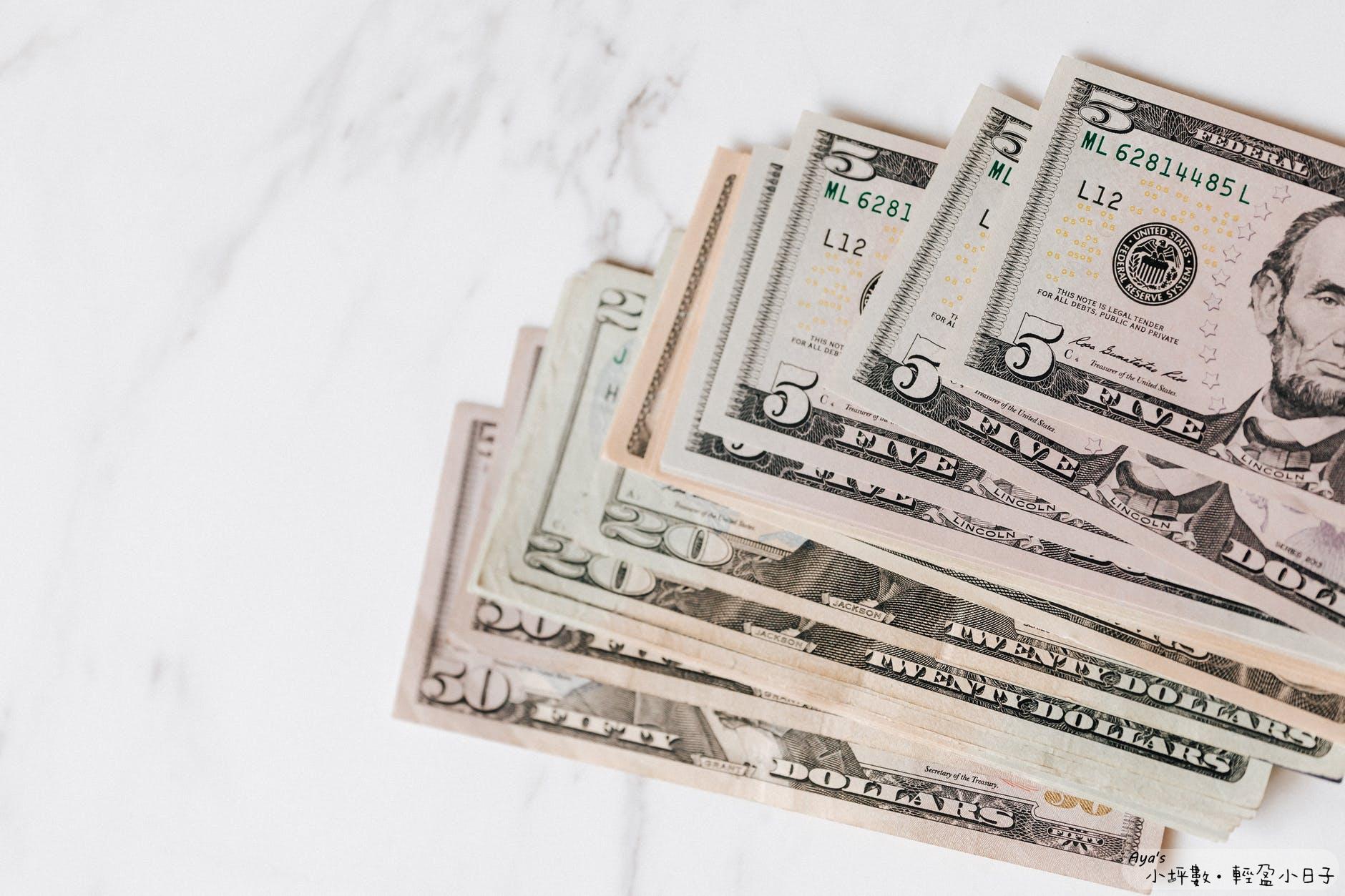 different dollar bills on marble surface
